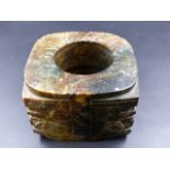 A CHINESE DARK GREEN AND BROWN HARDSTONE CONG, THE SQUARED CORNERS OF THE EXTERIOR ENCLOSING THE