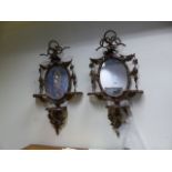 A PAIR OF VICTORIAN GILT OVAL WALL MIRRORS EACH WITH THREE SHELF BRACKETS AND DECORATED WITH BIRDS
