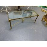 A BRASS LOW TABLE WITH INSET GLASS TOP ON REEDED SUPPORTS. W.100 X H.40CMS.