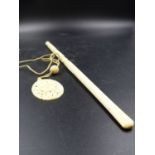 A CHINESE CARVED IVORY CIGARETTE HOLDER. 30CMS AND AN OVAL PENDANT ALSO PIERCED AND CARVED WITH