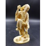 A JAPANESE IVORY FIGURE OF A SWORDSMAN SURPRISED BY A SNAKE AMONGST THE FLOWERS HE HAS BEEN
