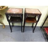 A PAIR OF CHINESE CARVED HARDWOOD STANDS WITH INSET MARBLE TOPS AND CONFORMING UNDERTIERS ON PAW