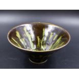 A CHINESE TRUNCATED CONICAL BOWL, THE TREACLE BLACK GLAZED SPLASHED AND STREAKED IN GREEN. DIA.14.