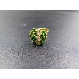 AN 18CT YELLOW GOLD DIAMOND AND EMERALD RING. THE THREE CENTRAL DIAMONDS ARE OVAL CUT, EACH
