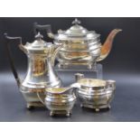 A SILVER HALLMARKED FOUR PIECE TEA SERVICE COMPRISING OF A TEAPOT, A HOT WATER POT, SUGAR BOWL AND