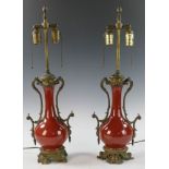 Pair of red-glazed porcelain vases, 26"h. Vase size 11"h.