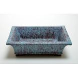 The planter covered overall and on the base with an opaque glaze of mottled turquoise and blue