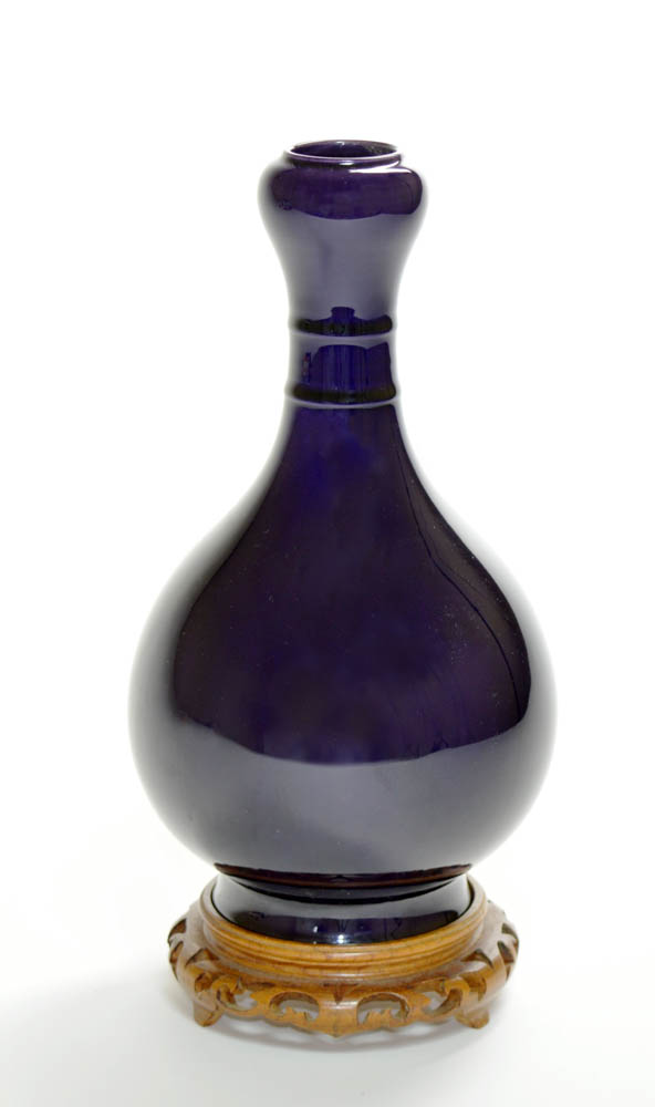 The vase raised on a tall spreading foot, and covered on the exterior with a deep aubergine glaze.