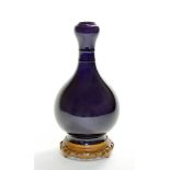 The vase raised on a tall spreading foot, and covered on the exterior with a deep aubergine glaze.