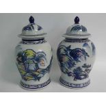 Two modern lidded vases with Oriental painted scenes and blue printed Grecian rim, together with