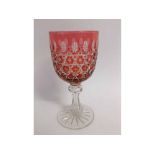 Large cranberry and flash cut glass goblet with a faceted bowl, a clear glass stem on a starburst