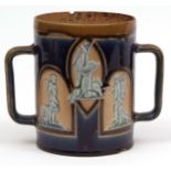 Royal Doulton stoneware two-handled loving cup, moulded with panels of shooting scenes, figures with