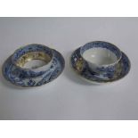 English blue and gilded tea bowl and saucer and a further blue printed tea bowl and saucer with a