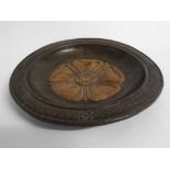 Early 20th century darkened/light oak circular bowl, the centre carved with a Yorkshire rose,