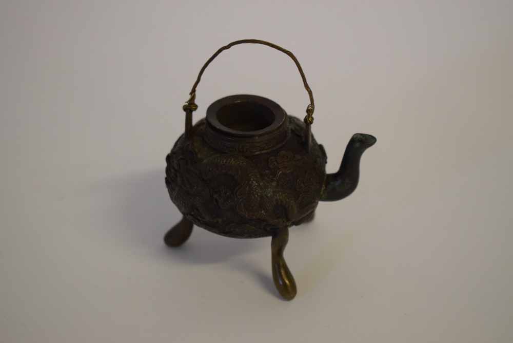 20th century bronze Oriental small kettle on a three-footed base with cast and raised dragon design,