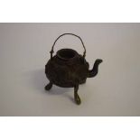 20th century bronze Oriental small kettle on a three-footed base with cast and raised dragon design,