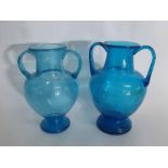 Pair of decorative blue glass urn style vases applied with two handles and a circular foot,