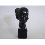 Bronze head of an Eastern lady wearing earrings, raised on a square ebonised plinth, 16cms tall