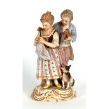 20th century Meissen figure group, a lady and gent with dog seated on a gilded scrolled base,