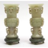 Pair of finely carved Chinese jade vases on jade stands, the vases celadon in colour of Gu form with