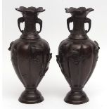Pair of Japanese bronze vases heavily cast with birds amidst shrubbery, applied elephant handles,
