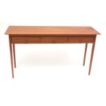 Mid-century teak side table of plain rectangular form, with three frieze drawers, the handles all