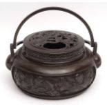 Chinese lidded bronze censer or handwarmer of circular form with double swing handles, the sides
