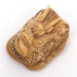 Japanese ivory netsuke (possibly marine ivory) well carved as a compact coiled dragon grasping a