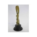 Art Deco style brass car mascot in the form of a seated hare, with ears raised, on an ebonised