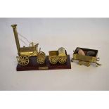 Brass scratch built Stephenson's Rocket on a teak plinth, together with a further brass formed