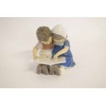 Royal Copenhagen figure group of a young boy and girl reading a book, model no 1567, 10cms tall