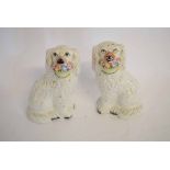 Pair of Staffordshire dogs with painted features, with white bodies and basket of flowers in their