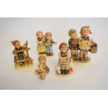 Group of five Goebel Hummel figures to include a group of a young boy and girl with basket on her