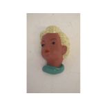 Goldscheider terracotta wall mask of a young girl with blonde hair and a green neck scarf, with