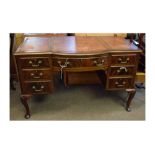 Edwardian mahogany desk with bow fronted central drawer, flanked either side by three drawers with