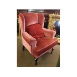 Mid-20th century puce upholstered wing armchair on beechwood stained front legs