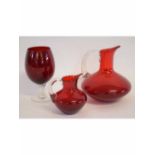 Group of three ruby glass items to include two jugs with clear glass reeded handles, together with a