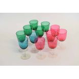 Set of five cranberry bowl wine glasses with clear stems together with a further set of five Bristol