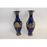 Pair of Royal Doulton mottled blue ground vases with a flared neck, with raised floral detail,