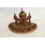 Oak table top pipe stand with central lidded urn and six compartments with turned treen bowls, 32cms