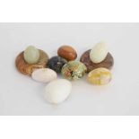 Tub containing six assorted agate eggs with two circular stands, together with a further treen