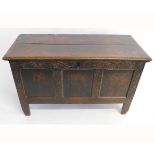 18th century oak coffer with three panelled front with a carved swirl design and planked top, with