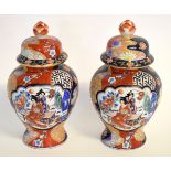 Pair of 20th century lidded vases, decorated in Imari colours with figural panels, with red