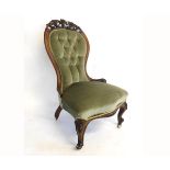 Victorian walnut carved nursing chair with green Dralon upholstered seat and button back, with