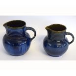 Graduated set of two Bourne Denby blue glazed jugs with ribbed necks and shaped handles, tallest