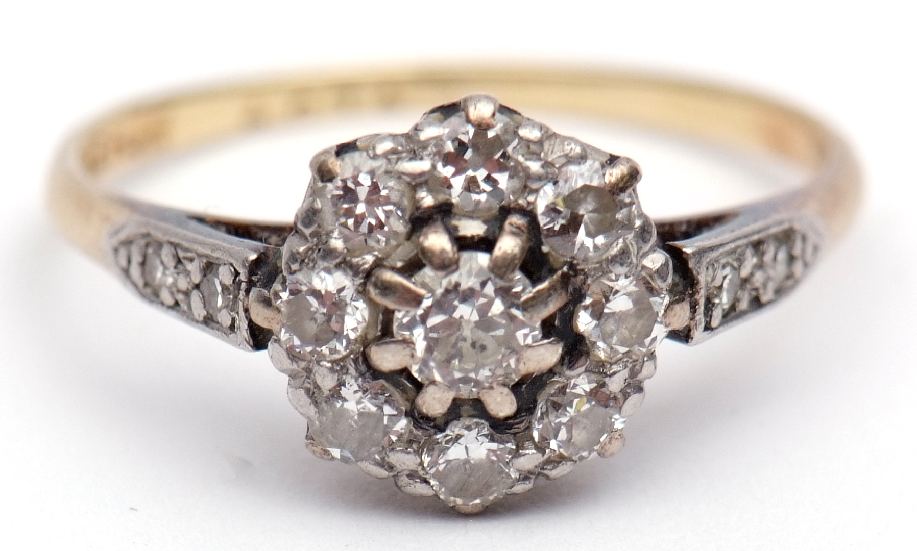 Precious metal diamond cluster ring, the principal diamond 0.15ct approx, raised within a surround