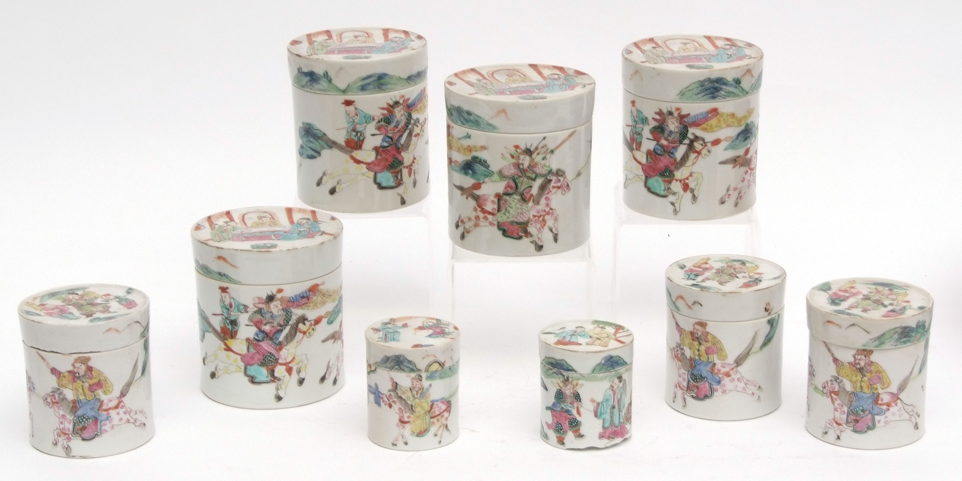 Nine Chinese porcelain circular pots and covers in three graduated sizes, decorated in famille