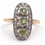 Modern precious metal diamond and peridot ring, the oval shaped pierced panel having three bezel set