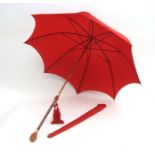 Oriental red silk parasol with bamboo stem and finely carved nut handle, showing a crying child,