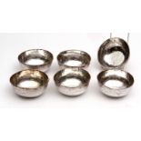 Six Middle Eastern white metal bowls of circular form with chased and engraved decoration and